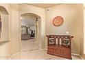 Warm foyer featuring tile floors, an archway, and a wooden bench with decorative pillows at 17651 N Coconino Dr, Surprise, AZ 85374