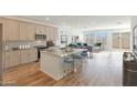 Bright, open-concept kitchen with island seating, modern cabinetry, and stainless steel appliances, flowing into the living area at 17969 W Sand Hills Rd, Surprise, AZ 85387