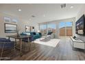 Open living space with large windows, modern furnishings, and a seamless transition to an outdoor patio at 17969 W Sand Hills Rd, Surprise, AZ 85387