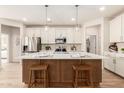 Modern kitchen featuring a central island with bar seating, stainless steel appliances, and pendant lighting at 18244 W Soft Wind Dr, Surprise, AZ 85387