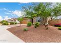 A charming, single-story home with desert landscaping, a brick driveway, and neutral exterior paint at 18453 W Elwood St, Goodyear, AZ 85338