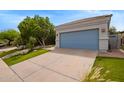 Single-story home featuring a blue garage door and desert landscaping at 19606 N 23Rd Way, Phoenix, AZ 85024
