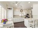 All-white kitchen featuring a ceiling fan and breakfast bar at 19606 N 23Rd Way, Phoenix, AZ 85024