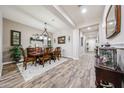 Formal dining room featuring wood flooring, a decorative chandelier, and seating for six guests at 20421 W Legend Trl, Buckeye, AZ 85396