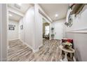 Bright foyer with wood-look tile flooring, an entryway table with flower arrangement, and neutral wall paint at 20421 W Legend Trl, Buckeye, AZ 85396