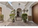 Covered entry courtyard with iron gate and mature potted plants create inviting curb appeal at 211 W New Dawn Dr, Chandler, AZ 85248