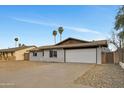 Single-story home features painted brick, desert landscaping, two-car garage, and driveway with access gate to the side yard at 2123 E Radcliffe Dr, Tempe, AZ 85283
