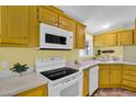 Charming kitchen with classic yellow cabinetry, white appliances, and durable countertops, perfect for everyday meal preparation at 701 S 92Nd St, Mesa, AZ 85208