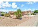 Charming home featuring desert landscaping and a tile roof at 7214 W Crest Ln, Glendale, AZ 85310