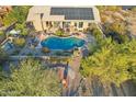 Stunning aerial view of a house with a private pool and solar panels on the roof at 11255 S San Adrian Ln, Goodyear, AZ 85338