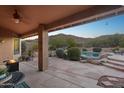Relaxing covered patio with a fire pit overlooking the pool and desert landscape at 11255 S San Adrian Ln, Goodyear, AZ 85338