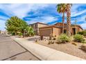 Street view of a stucco house with desert landscaping, a driveway, and palm trees at 1173 E Daisy Way, San Tan Valley, AZ 85143