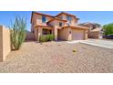 Two-story home featuring a spacious driveway with desert landscaping including a cactus and other greenery at 1556 E Gabrilla Dr, Casa Grande, AZ 85122