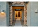 Covered entryway featuring a stone facade, a pathway, and a view of the front door at 16852 W Creedance Blvd, Surprise, AZ 85387