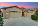 Spacious three-car garage with a wide driveway, offering ample parking and storage space for vehicles and equipment at 16852 W Creedance Blvd, Surprise, AZ 85387