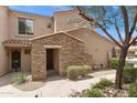 Charming entryway with stone accents, complemented by lush landscaping and a welcoming front door at 19475 N Grayhawk Dr # 2151, Scottsdale, AZ 85255