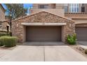 Close-up of a one-car garage with stone facade and driveway, perfect for parking or extra storage at 19475 N Grayhawk Dr # 2151, Scottsdale, AZ 85255