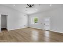 Bright living room featuring new floors, a modern ceiling fan, and a door with three glass panels at 2122 W Virginia Ave, Phoenix, AZ 85009