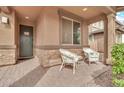 Inviting covered front porch featuring chairs and a side table to enjoy your morning coffee at 21667 S 225Th Way, Queen Creek, AZ 85142