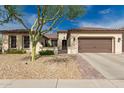 Charming single-story home featuring manicured landscaping, a brick-paved walkway, and an attached garage at 27007 N 20Th Ln, Phoenix, AZ 85085