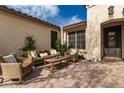 Inviting outdoor patio featuring wicker seating, a brick-paved floor, and lush greenery at 27007 N 20Th Ln, Phoenix, AZ 85085