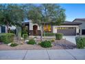 Inviting home exterior showcasing desert landscaping, a decorative front door, and a two-car garage at 2991 E Fandango Dr, Gilbert, AZ 85298