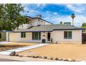 Charming two-story home featuring tidy desert landscaping, a balcony, and white brick exterior at 3038 E Avalon Dr, Phoenix, AZ 85016