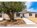 Charming single-story home featuring a tire swing, tidy desert landscaping, and white brick exterior at 3038 E Avalon Dr, Phoenix, AZ 85016