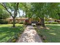 Landscaped front yard with mature trees, flowers, and a brick walkway leading to the home's entrance at 31 W Marlette Ave, Phoenix, AZ 85013