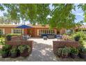 Inviting brick patio featuring comfortable seating and an outdoor dining area under a bright blue umbrella at 31 W Marlette Ave, Phoenix, AZ 85013