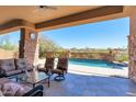 Comfortable covered patio featuring ample seating, stone accents, and serene views of the backyard oasis at 35195 N 98Th St # 85, Scottsdale, AZ 85262