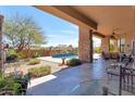 Inviting outdoor patio with stone columns, a shaded seating area, and views of the sparkling pool at 35195 N 98Th St # 85, Scottsdale, AZ 85262