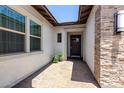 Inviting front entryway featuring a tiled walkway, stylish sconces, and decorative plants by the dark wood front door at 3856 E Shannon St, Gilbert, AZ 85295
