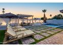 Stunning backyard featuring lounge chairs, a covered pergola, synthetic lawn, and a sparkling pool at 4033 W Sharon Ave, Phoenix, AZ 85029