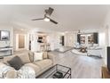 Open-concept living room featuring hardwood floors, neutral paint, ceiling fans, and modern furnishings at 4033 W Sharon Ave, Phoenix, AZ 85029