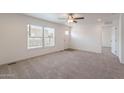 Inviting living room featuring neutral carpeting, a ceiling fan, and large windows that provide ample natural light at 46 S 96Th St, Mesa, AZ 85208