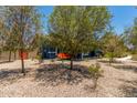 Backyard with seating, mature trees, and a gravel yard creating a serene and inviting outdoor space at 5321 N 196Th Ave, Litchfield Park, AZ 85340