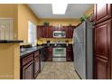 Kitchen featuring stainless steel appliances, dark cabinets, and tiled floors at 5335 E Shea Blvd # 1094, Scottsdale, AZ 85254
