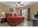 Comfortable main bedroom with ceiling fan, window and sun themed decoration at 5335 E Shea Blvd # 1094, Scottsdale, AZ 85254