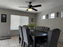 Dining room featuring a ceiling fan, gray tufted chairs, and a large window for plenty of natural light at 6538 W Nez Perce St, Phoenix, AZ 85043
