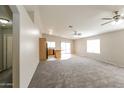 Spacious living room featuring neutral walls, ceiling fans, carpeted floors, and natural light at 8832 W Manzanita Dr, Peoria, AZ 85345