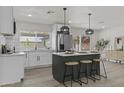 Bright kitchen with modern island, pendant lighting, stainless steel appliances, and views of the backyard at 10612 N 48Th Ave, Glendale, AZ 85304