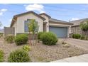 Beautiful home exterior with stone landscaping and a well-maintained two-car garage at 12105 W Wier Ave, Avondale, AZ 85323