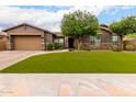 Charming single-story home with a well-manicured front yard, complemented by desert landscaping and a neutral color scheme at 12834 W Forest Pleasant Pl, Peoria, AZ 85383