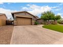 Charming single-story home with a well-manicured front yard, complemented by desert landscaping and a neutral color scheme at 12834 W Forest Pleasant Pl, Peoria, AZ 85383