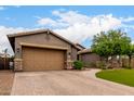 Charming single-story home with a well-manicured front yard, complemented by desert landscaping and a neutral color scheme at 12834 W Forest Pleasant Pl, Peoria, AZ 85383