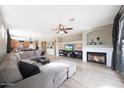 Spacious living room boasts a cozy fireplace, ceiling fan, and comfortable seating at 16039 W Pima St, Goodyear, AZ 85338