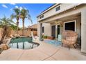 This backyard features a pool, covered patio, ceiling fan, lounge seating, and palm trees at 16139 N 171St Ln, Surprise, AZ 85388