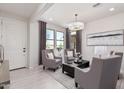Bright living room features tile floors, modern lighting, neutral-toned decor, and ample natural light at 18247 W Soft Wind Dr, Surprise, AZ 85387