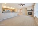 Open-concept living room with a fireplace, ceiling fan, and abundant natural light at 20750 N 87Th St # 2062, Scottsdale, AZ 85255